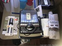 Photo of Krups Panini Machine closed with Misto oil sprayer, KitchenAid hand blender bag, Escali digital scale, and Cuisinart drying mat beside it.