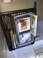 Plastic crate containing several small wooden photo frames, assorted music CDs, and a clear plastic storage container with additional CDs inside.