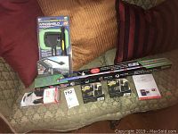 Full lot displayed on couch showing all items including Windshield Wonder cleaner, vehicle charger, SD card, and bulbs.