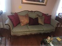 Front view of Victorian style couch with five decorative throw pillows