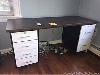 Full view of metal frame desk with wood laminate top and drawers.