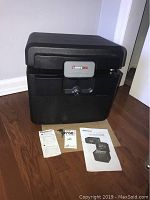 Full view of black Sentry Safe with keys and owner's manual displayed in front