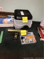 Staples black shredder wrapped in plastic bag, 23 inches tall, on floor with office supplies tray and lamp.