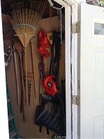 Photo showing the hedge trimmer and leaf blower hanging on pegboard along with shovels and other long-handled tools