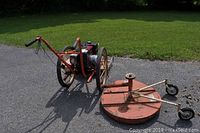 Main unit and circular mower attachment side by side on driveway