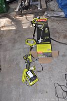 Ryobi 40V 13" cordless string trimmer with edger head next to its box, battery and charger visible