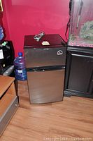Front view of Igloo mini bar fridge with freezer compartment closed, showing black stainless-steel finish and brand logo.