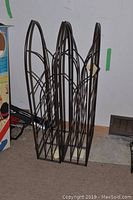 Photo showing two matching decorative iron stands with arched tops and geometric lattice design, measuring approximately 32 inches tall.