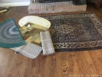 Overview of all rugs and mats laid on hardwood floor showing relative size and designs.