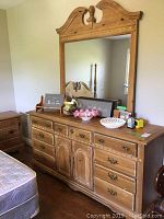 Front-wide shot of the wood dresser with attached mirror, showing ornate design and scratches