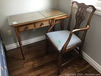 Desk and chair side-by-side with glass tops on desk