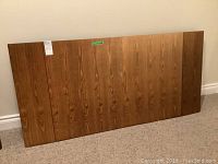 Full view of wood dining table surface showing two detachable extension leaves with visible wood grain and natural finish.