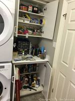 Cabinet and counter space showing assorted hardware and cleaning supply bottles and boxes.