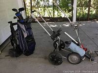 Full view of TaylorMade bag on Bag Boy cart with two additional carts and ball retriever