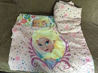 Folded sheet set showing fitted sheet with pink floral pattern and pillowcase with image of Elsa