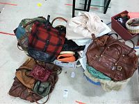 Overview of four boxes with assorted women's bags and purses in various materials including leather, fur, and basket styles