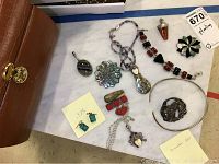 Overview of ten silver jewelry pieces and brown wooden jewelry organizer box with brass lock.