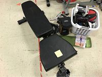 Adjustable weight bench close-up showing padded cushions and partial view of basket containing equipment.