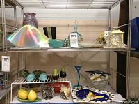 Full shelving unit display showing glass, ceramic, and clock items together