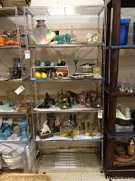 Two metal shelving units filled with various decorative home items, showing overall structure and shelves