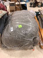 Large rolled LoveSac bean bag wrapped in clear plastic