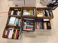 Seven boxes of books including Harry Potter series, The Hobbit, and assorted fiction and non-fiction books, viewed from top.