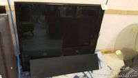 Front view of TV leaning on padded moving blanket with speaker grille removed