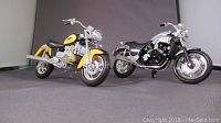 Front and side view of the two model motorcycles, yellow Yamaha VMax on left and black Honda Valkyrie F6 on right.