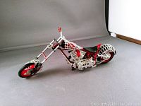 Front side angled view of the Orange County Choppers Black Widow model motorcycle showing spider web design and red rims.