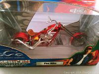 Side view of the Fire Bike model in its original unopened packaging showing detailed motorcycle model inside with box graphics.