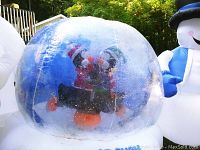 Inflatable snow globe showing dancing penguins inside and snow effect with a visible small patch on top.