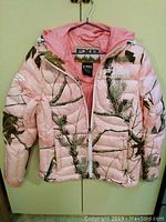 Front view of pink camouflage women's puff jacket with hood and full zipper.
