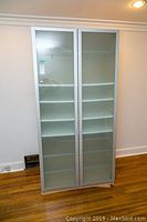 Front view of IKEA Pax Drammen cabinet showing two frosted glass doors and white interior shelves.