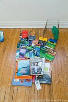 Overview of all books and metal rack arranged on the floor, showing variety of travel and business books