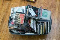Full bin filled with a large assortment of CDs stacked and spread out, showing album cover art such as Reservoir Dogs.