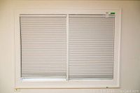 Full view of the two-panel cellular shade mounted in a white frame against a light wall.