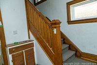 Photo showing full bannister installed on interior staircase, with newel post and adjacent wall detail.