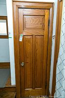 Full view of the wooden door including bottom panels, door knob, and surrounding trim.