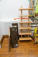 Overall view of the light wood shelving unit next to two dark wood shelves and one butcher block.