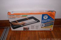 Photo of a boxed Fiskars 24-inch rotary paper trimmer showing the front of the box with product image and branding.