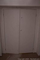 Two white interior doors with one closed and one door including a round white knob