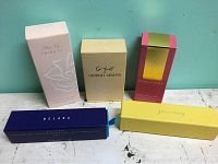 Five perfume boxes arranged on a table showing front labels.