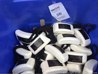 Bucket containing multiple white rectangular soaps attached to black ropes, black and gold labels visible.