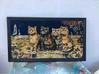 Full view of framed needlepoint artwork showing five cats sitting on a bench with outdoor scenery background.