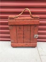 Front view of antique wooden crate painted red with stenciled text 'EXPLOSIVE MINE R7PJA LOT LDP- 14-131' and rope handle on top.