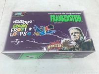 Photo of the front/top of the box showing branding and character graphics for the Frankenstein Monte Carlo car model from Kellogg's Spooky Froot Loops and Universal Monsters series by Revell.