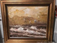 Full view of the framed oil painting depicting a seascape with birds and waves in brown and beige tones.