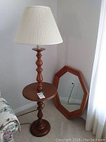 Vintage Roxton wooden floor lamp with integrated table and white pleated fabric lampshade, shown next to floral upholstered furniture.