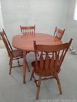 Oval maple table with one leaf inserted and four chairs around