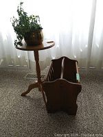 Vintage wooden magazine rack in light wood with spindle sides and open slot handles, showing side view